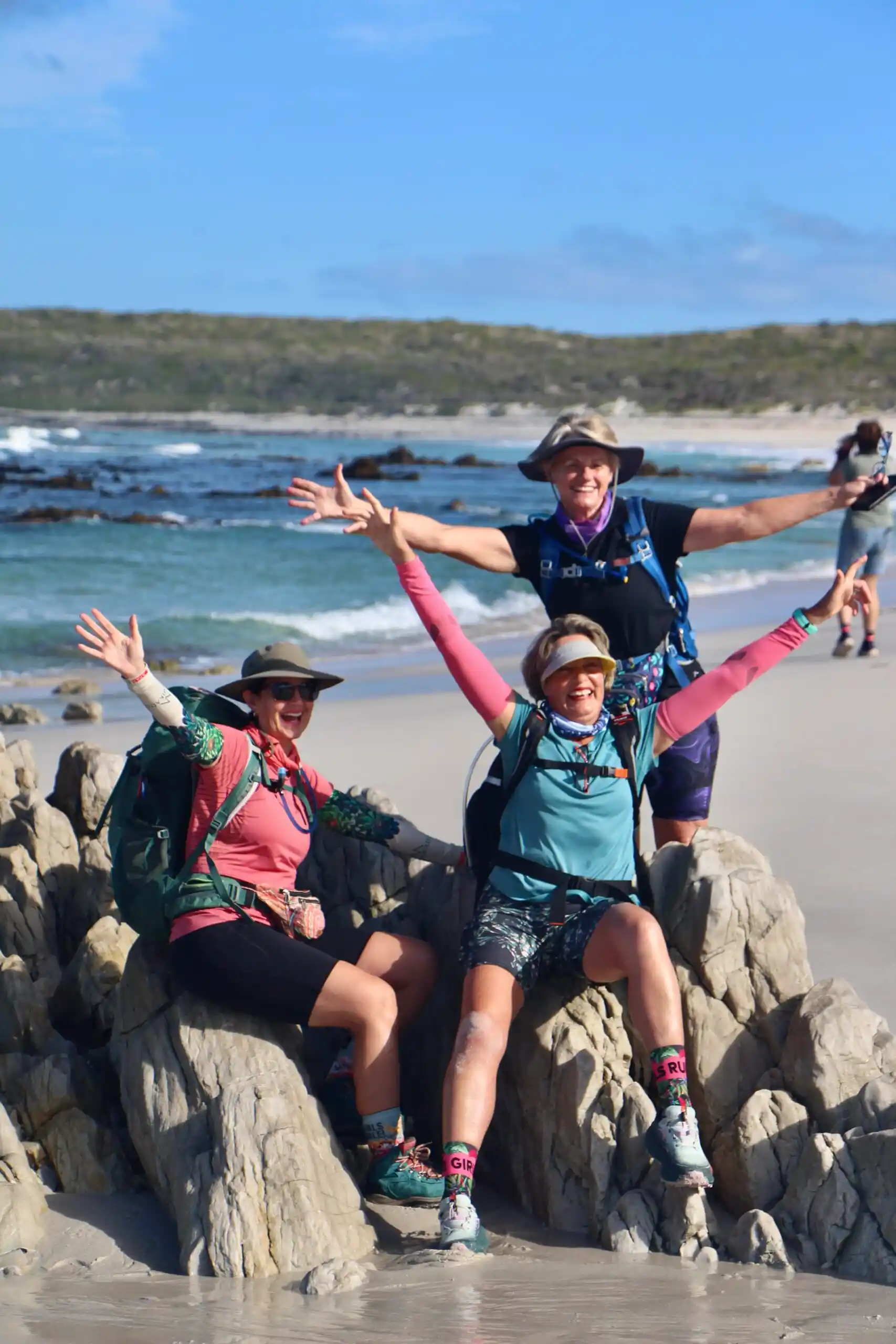 Hikers jumping for joy on Pearly Beach shoreline